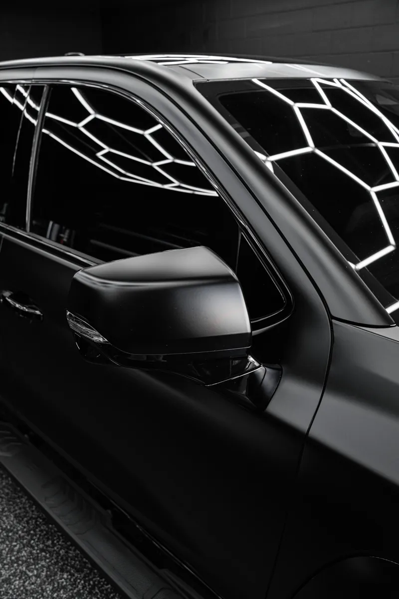 Mirror and A-pillar on a satin black Chevrolet pickup