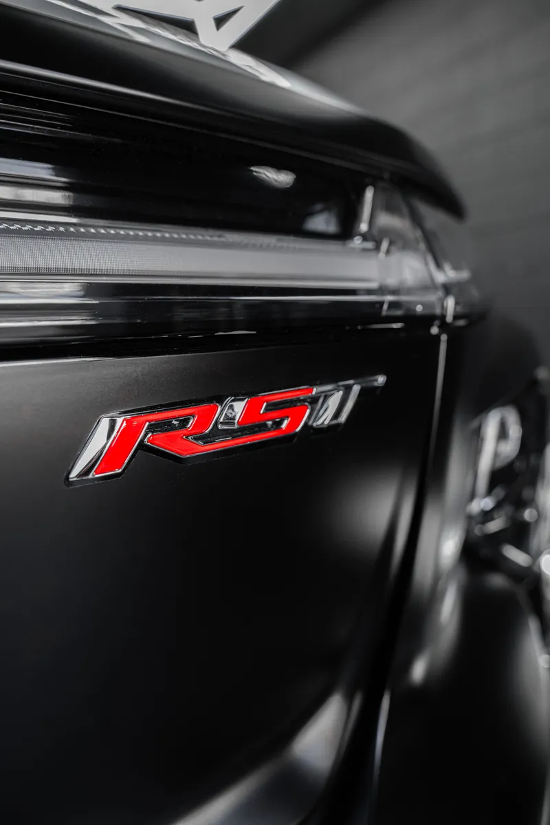 Red RST badge on a satin black Chevrolet pickup