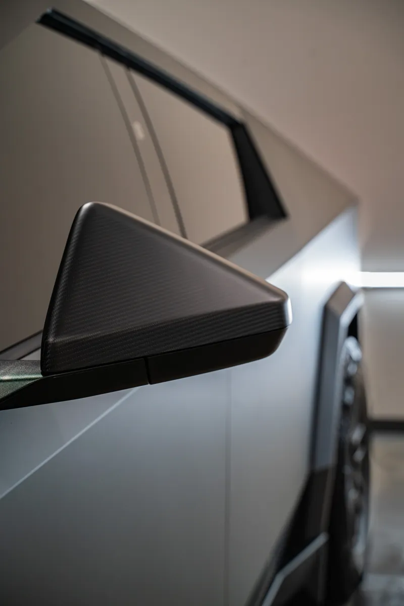 Carbon mirror and A-pillar of a grey-olive Tesla Cybertruck