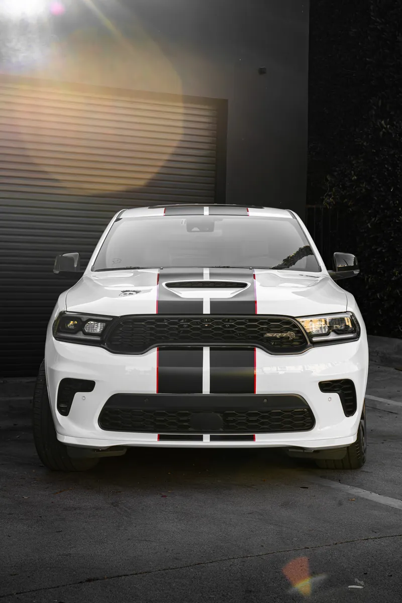 Front of a white Dodge Durango SRT with black stripes over the hood and bumper