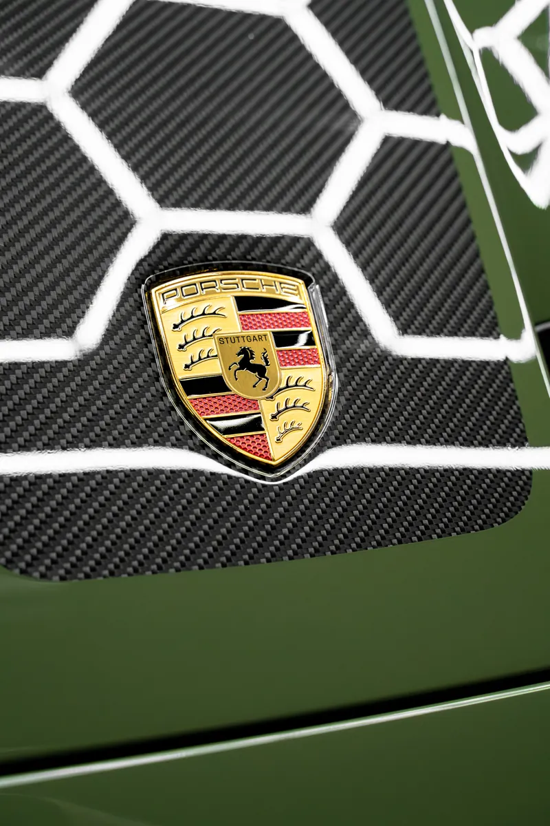 Porsche crest on the hood of an olive green 911 GT3