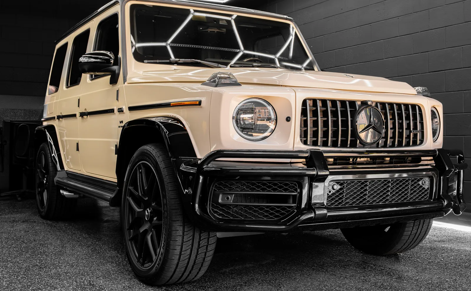 Beige Mercedes-AMG G63 with a vinyl wrap and gloss black accents