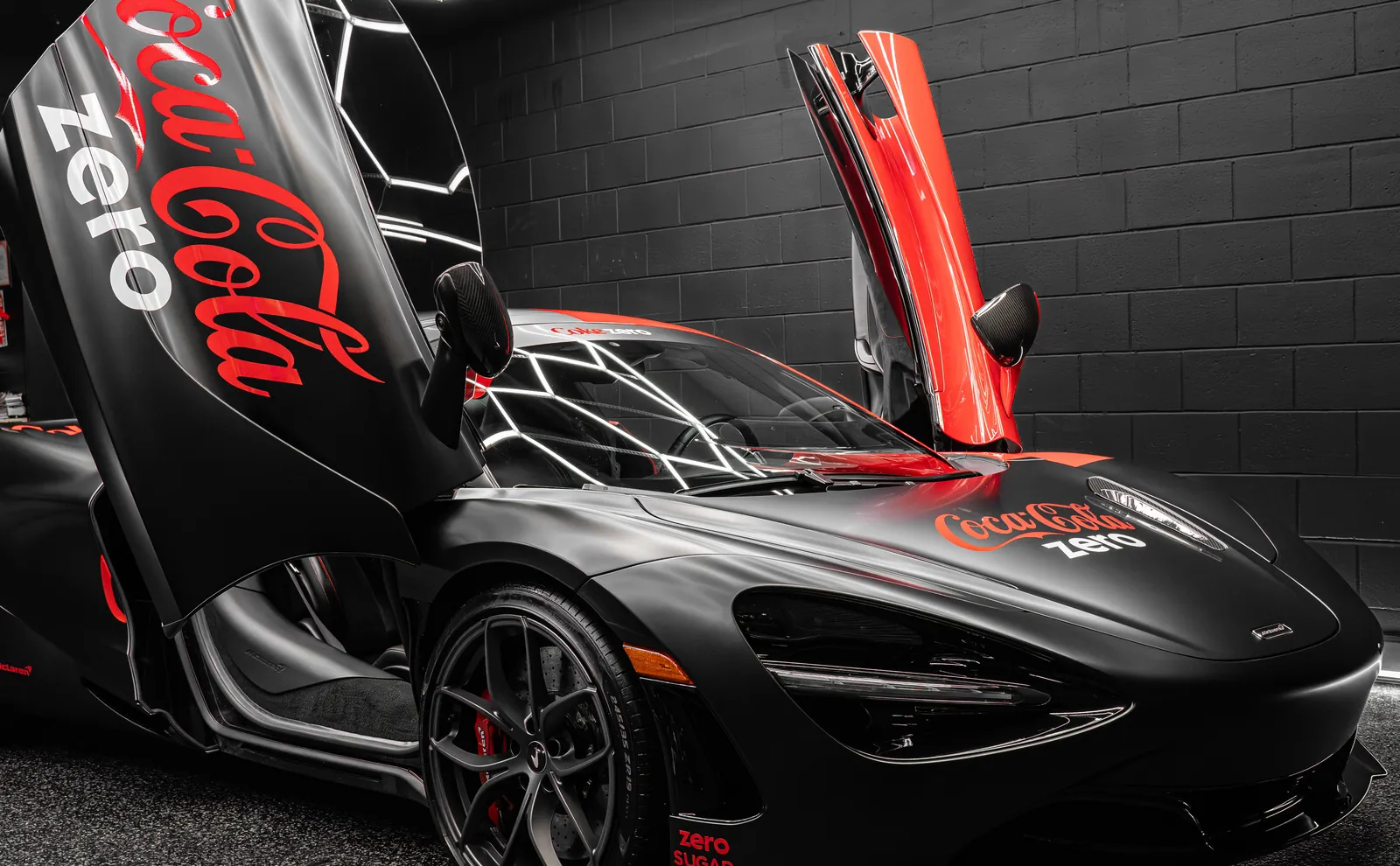 McLaren 720S with a red and black two-tone custom livery vinyl wrap, doors raised