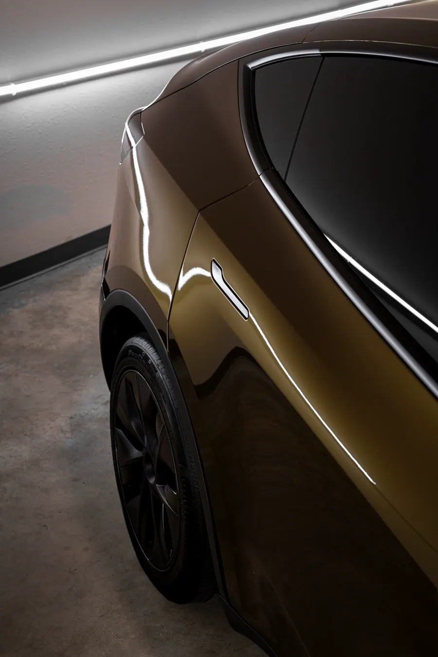 Close-up of a bronze wrap on a Tesla Model Y fender