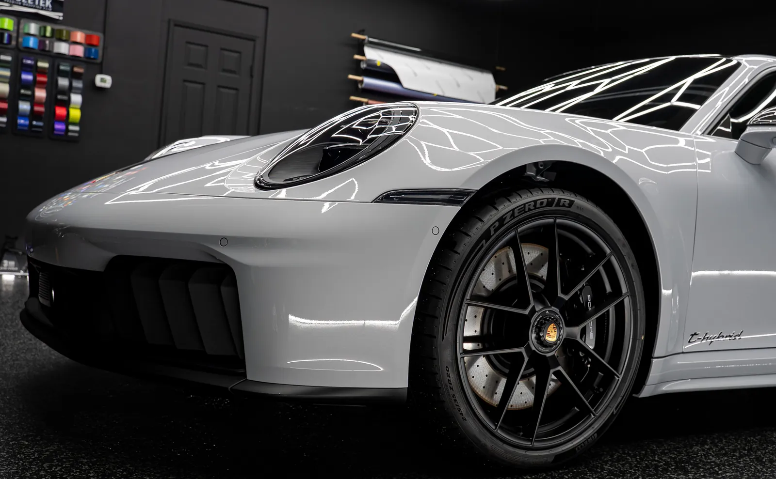 Front fender and black wheel of a light grey Porsche 911 Carrera GTS