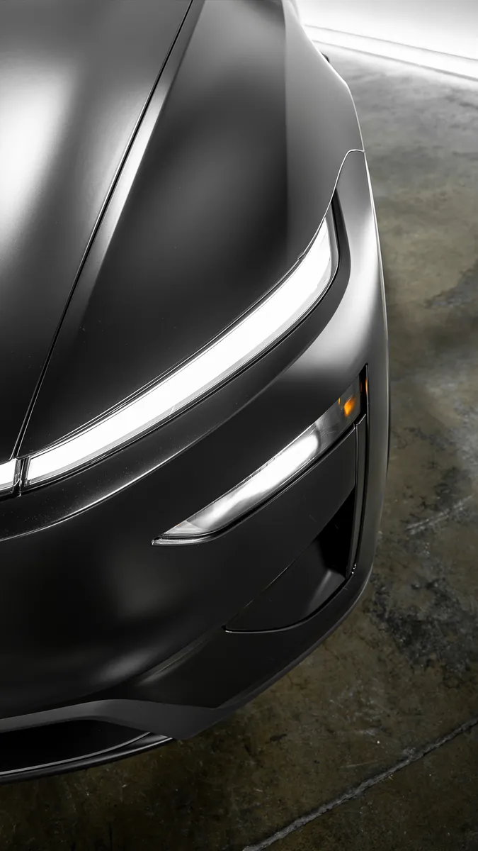Headlight close-up on a Tesla Model Y Performance with satin Stealth film